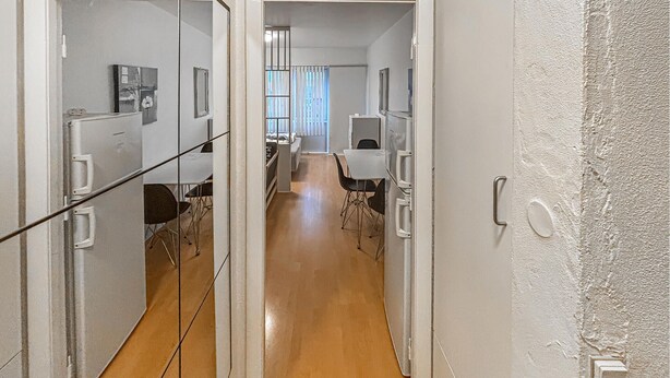 A corridor with a wooden floor, white walls, and a glass partition. There are chairs and tables in the distance. - Nice apartment in Esbjerg with WiFi (Esbjerg)