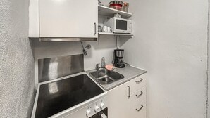 A compact kitchenette with a stainless steel sink, a microwave, a coffee maker, and a stove. - Nice apartment in Esbjerg with WiFi (Esbjerg)