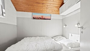 A bedroom with a wooden ceiling, a cityscape view, a bed with white bedding, and a white wall. - 3 bedroom amazing home in Nørre Nebel (Nørre Nebel)