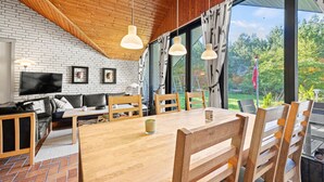 A modern living room with a brick wall, wooden ceiling, and large windows. - 3 bedroom amazing home in Nørre Nebel (Nørre Nebel)
