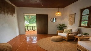A room with a tiled floor, wicker furniture, a woven rug, a hanging light fixture, and a view through an open door. - Paradise in Koh Phangan with Fast Internet (Ko Pha-ngan)