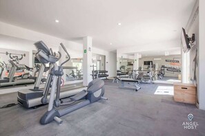 Ein Fitnessstudio mit Laufbändern, Kraftgeräten und Spiegeln.