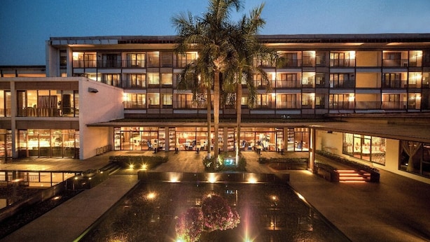 A multi-story hotel with a central courtyard, palm trees, and a pool. - Baiyun Lakeside Hotel (Guangzhou)