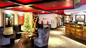 A lobby with a reception desk, seating area, and a Christmas tree. - BC Lodge King Suite | Fireplace | Village Location (Beaver Creek)
