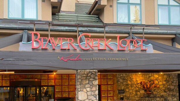 The exterior of the Beaver Creek Lodge with a stone facade, a large entrance with glass doors, and a sign above the entrance. - BC Lodge King Suite | Fireplace | Village Location (Beaver Creek)