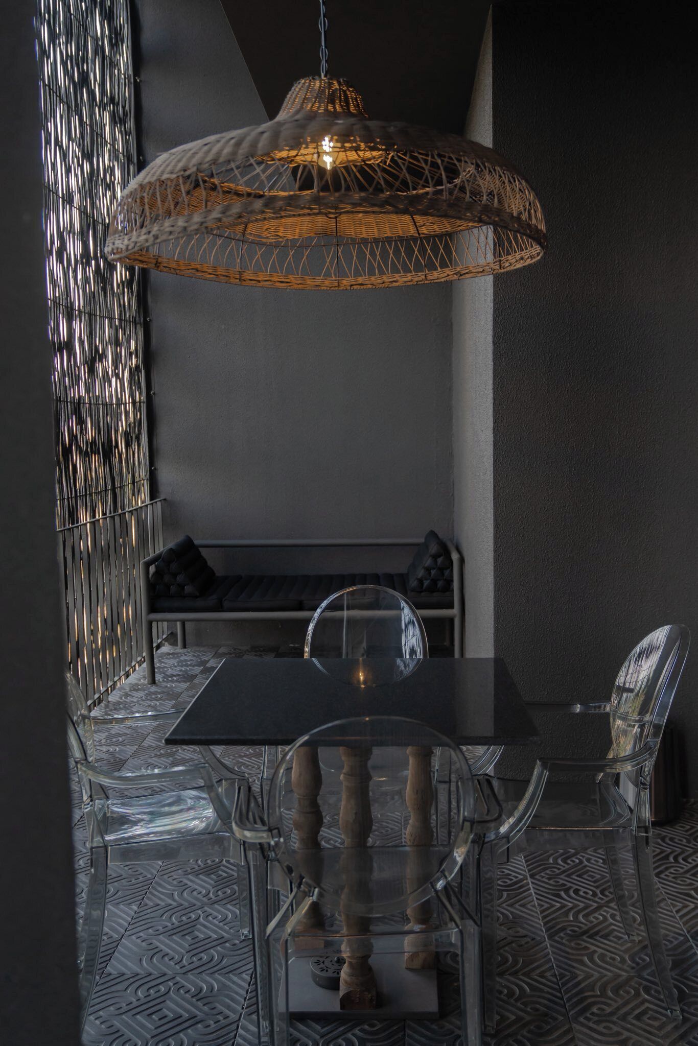 A dining area with a table, chairs, a bench, and a hanging light fixture.
