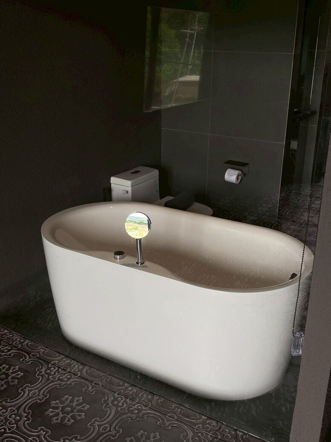 Ein modernes Badezimmer mit freistehender Badewanne, Toilette und Duschbereich.