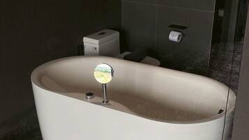 Ein modernes Badezimmer mit freistehender Badewanne, Toilette und Duschbereich.