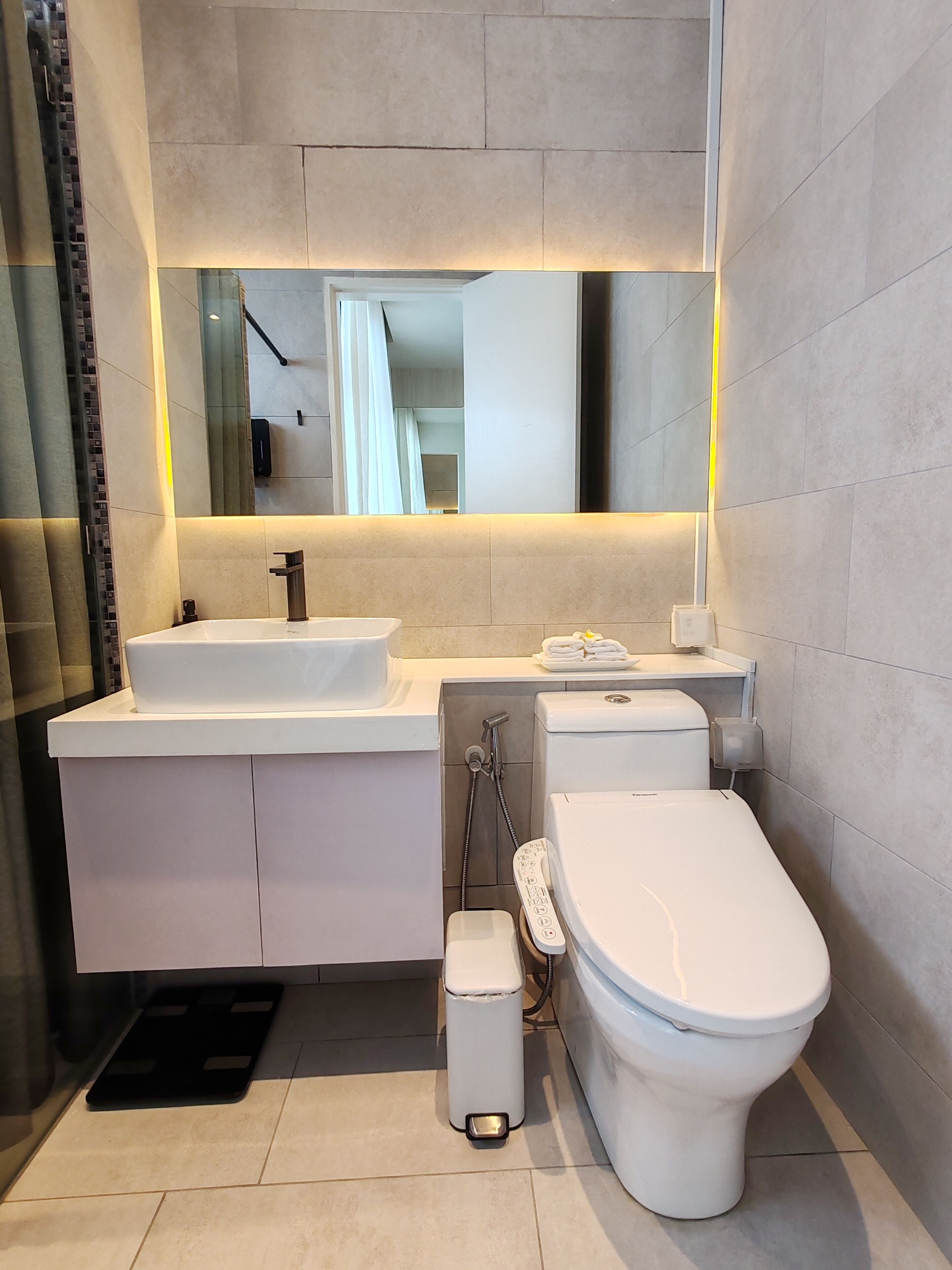 Ein modernes Badezimmer mit Waschbecken, Spiegel und Toilette.