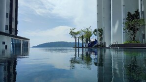 Un edificio moderno con una piscina che riflette il cielo e gli alberi.