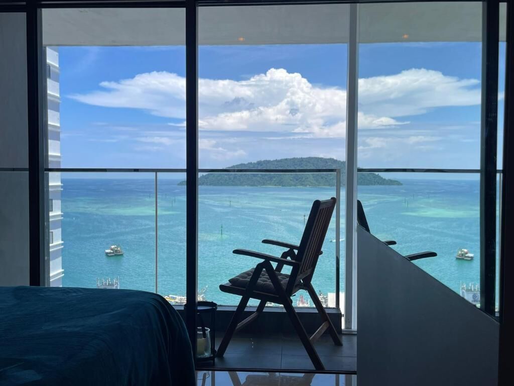 Un balcon avec vue sur la mer et une île.