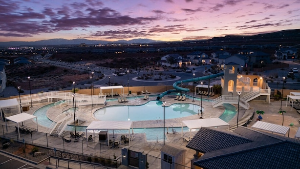 Ein Resort mit großem Pool, Wasserrutsche und überdachtem Bereich mit Liegestühlen.