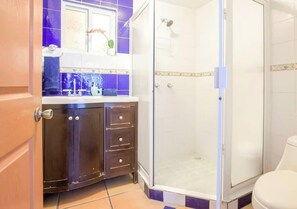 Une salle de bain équipée d’une douche, de toilettes et d’un meuble-lavabo avec des placards.