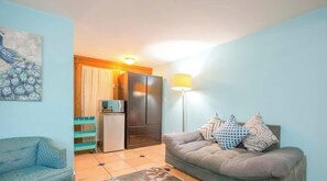 A living room with a sofa, a small table, and a cabinet. - Private Suite Ideal for Solo Travelers Or Couples (La Paz)