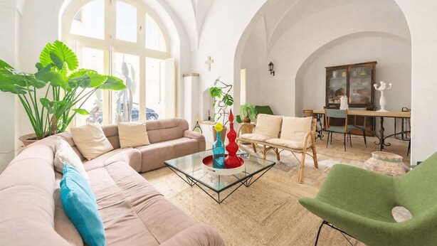 A spacious living room with a large window, a sofa, a coffee table, and a dining area. - Dimora Alexanos by Symphonya Rentals (Alessano)