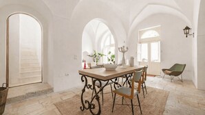 A dining area with a table, chairs, and a chandelier. - Dimora Alexanos by Symphonya Rentals (Alessano)
