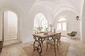 Zona pranzo con tavolo, sedie e lampadario.
