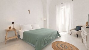 A bedroom with a bed, bedside table, lamp, chair, and a large mirror. - Dimora Alexanos by Symphonya Rentals (Alessano)