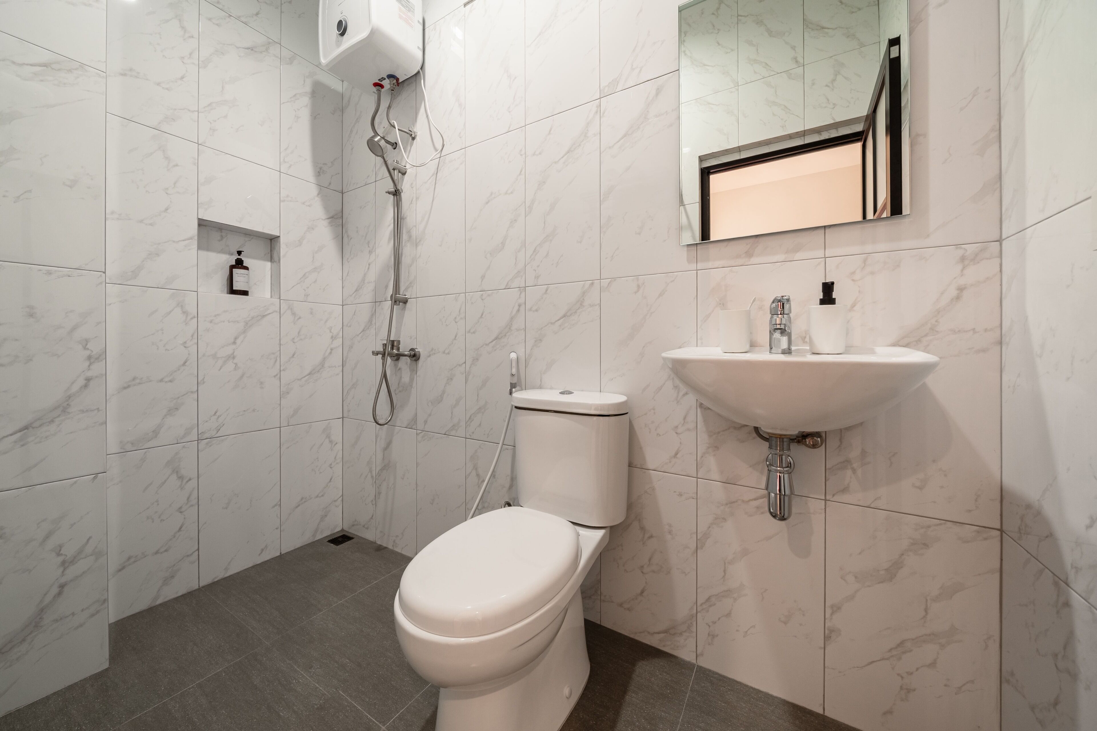 Une salle de bain moderne équipée de toilettes, d’une douche et d’un lavabo.