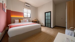 Una moderna camera d'hotel con un ampio letto, un comodino e una finestra con vista.