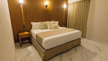 Un dormitorio moderno con una cama grande, paneles de madera y una mesita de noche.