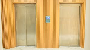 A pair of elevators with a control panel between them. - Hotel JVD Inn - Tonalá Centro (Tonalá)