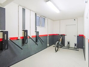 A clean, well-lit indoor space with a motorcycle, exercise equipment, and a door.