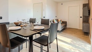 A modern dining area with a rectangular table, chairs, and a sofa. - Garda Oasis and Horizon by Interhome (Riva del Garda)
