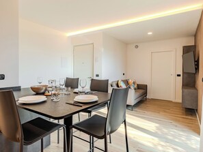 A modern dining area with a rectangular table, chairs, and a sofa. - Garda Oasis and Horizon by Interhome (Riva del Garda)