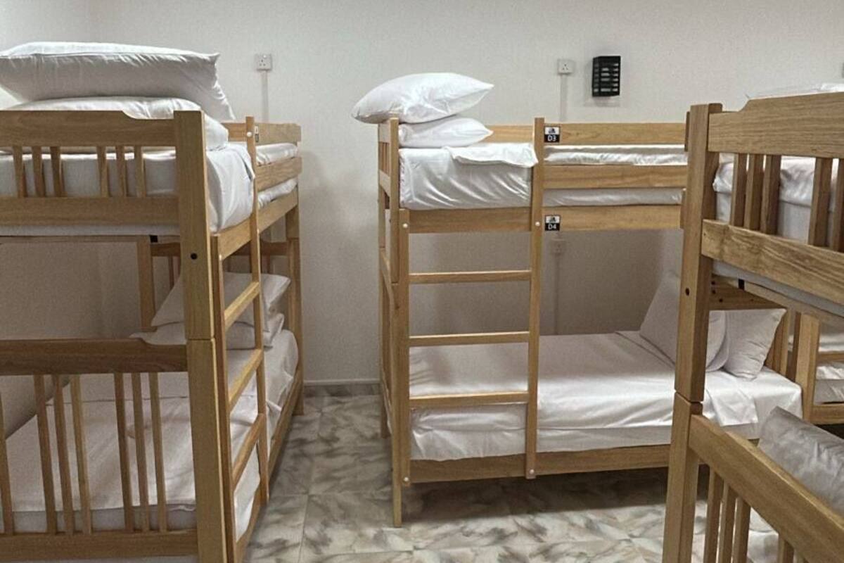 Una stanza con letti a castello, una ventola a soffitto e un lampadario.