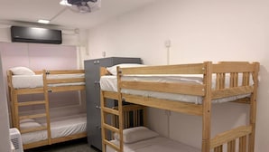 A dormitory room with bunk beds, a desk, a chair, and a refrigerator. - Hostel City Centre by Janatha (Colombo)