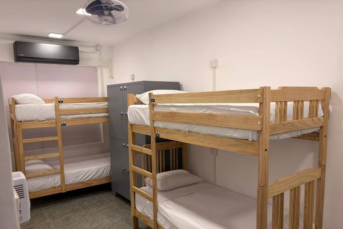 Una camera del dormitorio con letti a castello, una scrivania, una sedia e un frigorifero.