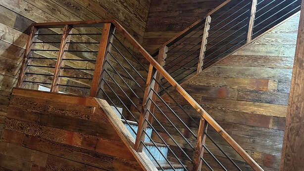A wooden staircase with metal railings inside a building.