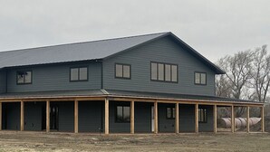 A large, single-story building with a flat roof and a covered porch area.