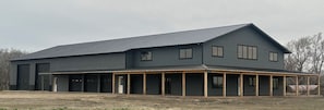Un edificio ampio, a un solo piano, con tetto piatto e veranda coperta.