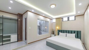 Une chambre moderne dotée d’un grand lit, d’un dressing et d’un espace douche.