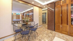Un espace repas comprenant une table et des chaises, un miroir, des meubles en bois et un ascenseur.