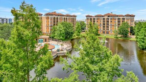 Un hôtel à plusieurs étages doté d’une piscine entourée d’arbres.