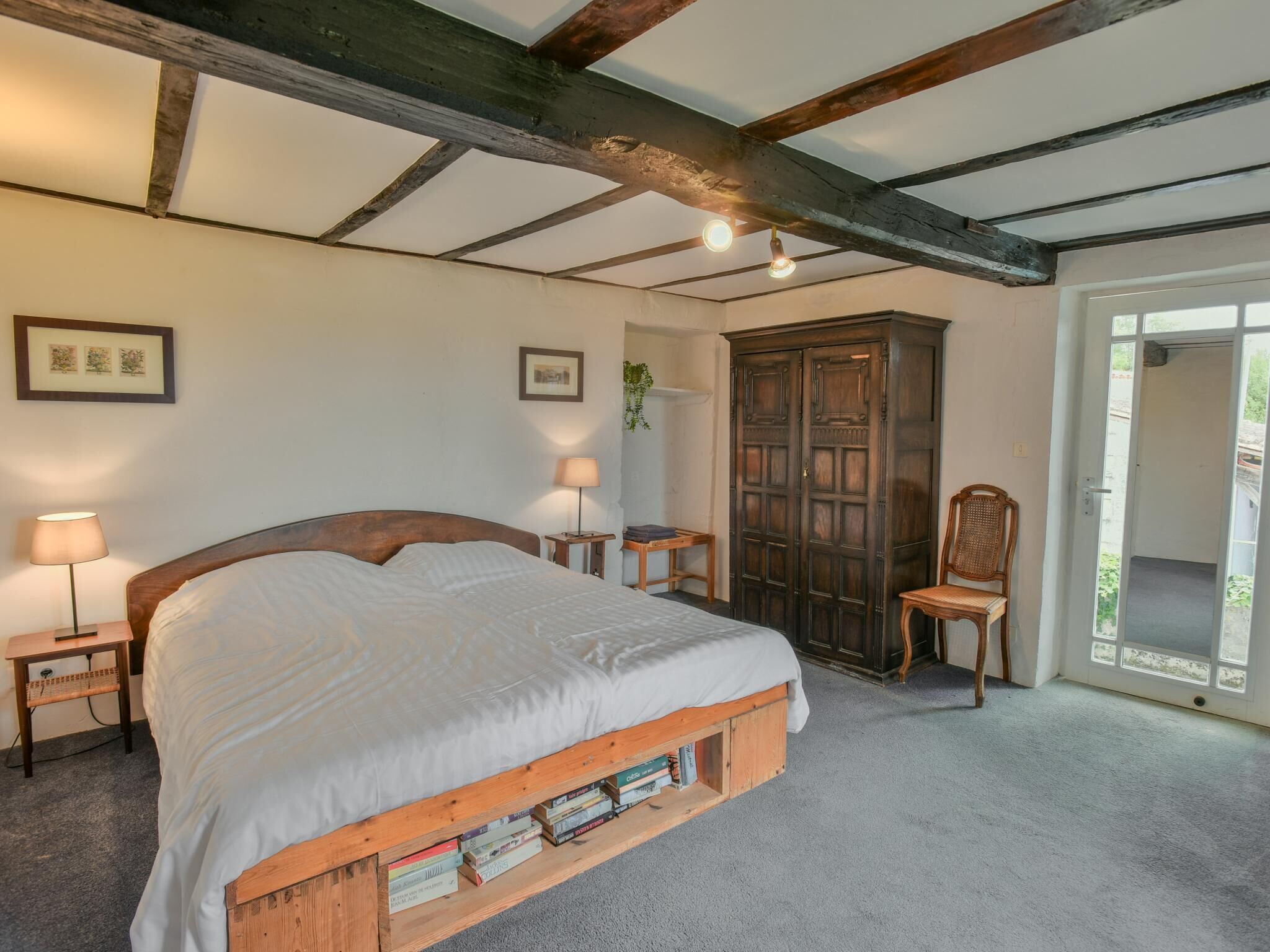 Une chambre à coucher avec un lit en bois, des lampes de chevet, une armoire et une chaise.