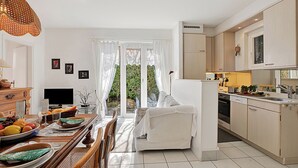 Eine moderne Küche mit Essbereich, einer Sitzecke und einem Fernseher.