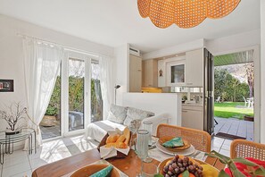 A well-lit room with a bed, dining table, and kitchen area. - Casa Viola Garden in Losone for 4 (Losone)