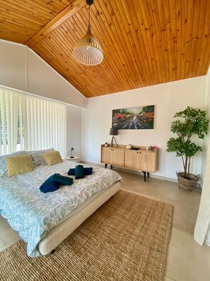 A bedroom with a bed, a wooden ceiling, a painting, a cabinet, and a potted plant. - Haven of peace: villa with private pool (Lorgues)