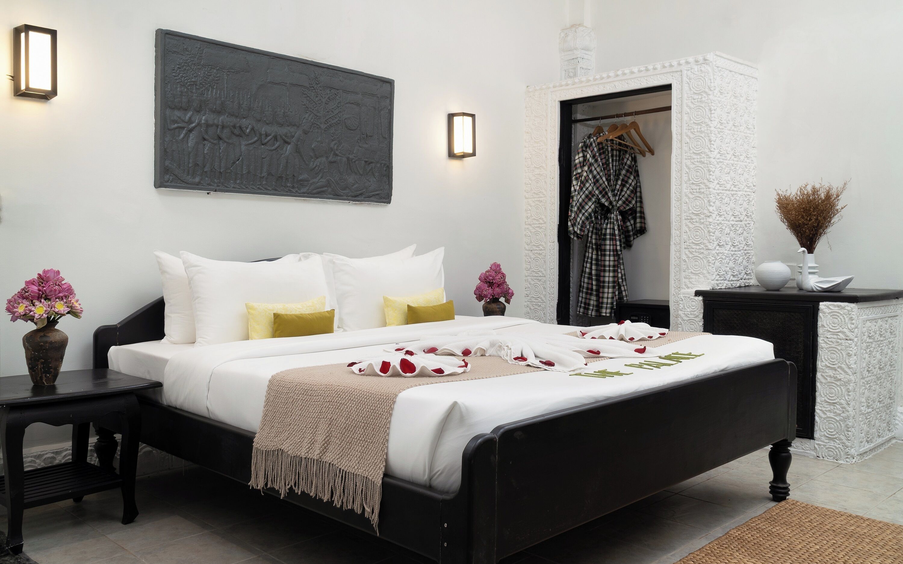 Une chambre bien rangée, avec un lit, des tables de chevet, une commode et une armoire.