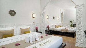 Habitación de hotel con dos camas, un espejo grande y una estatua decorativa de un elefante.