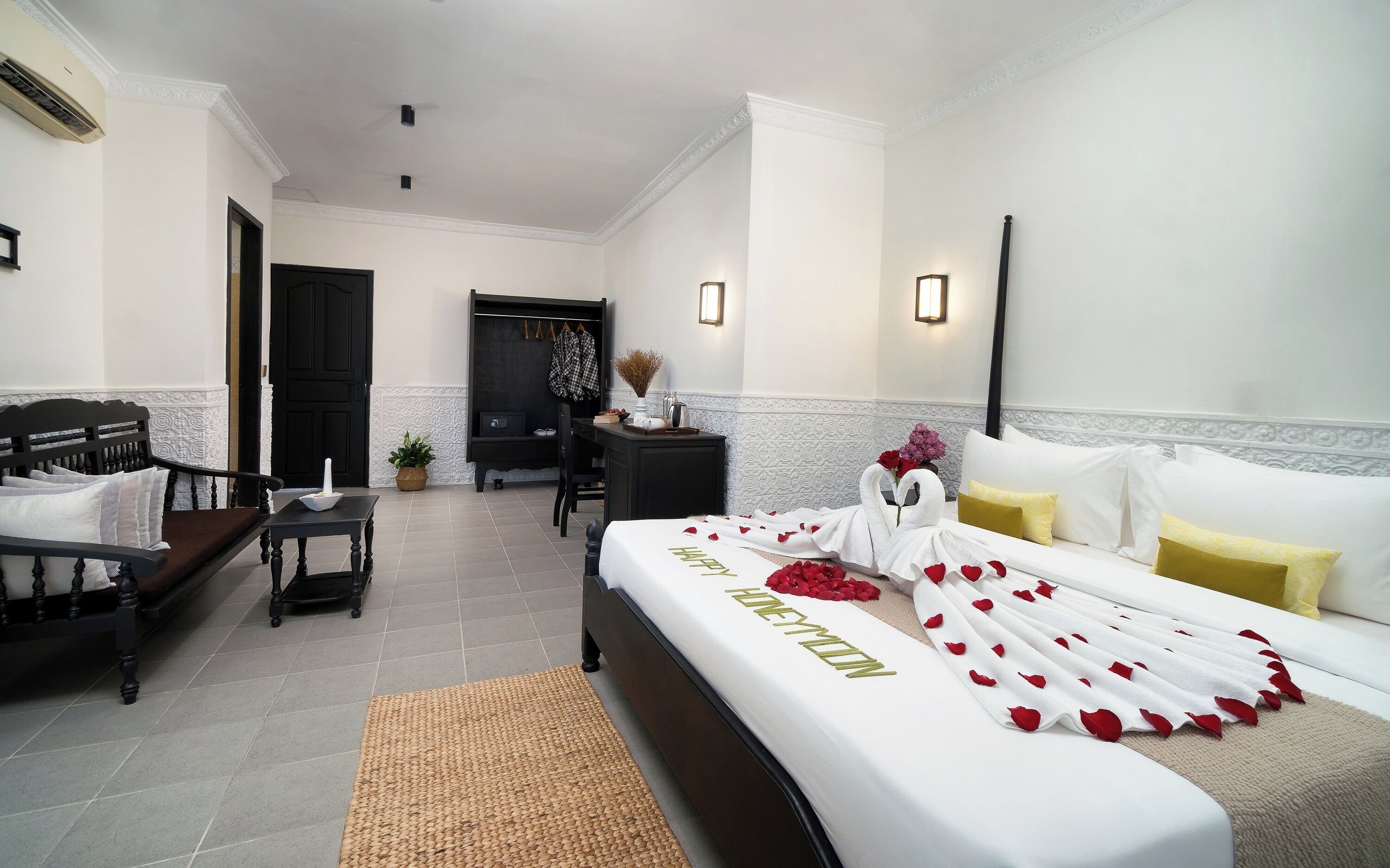 Une chambre d’hôtel avec un lit, un canapé, un bureau et une chaise.