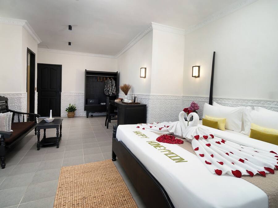 A hotel room with a bed, a sofa, a desk, and a chair.