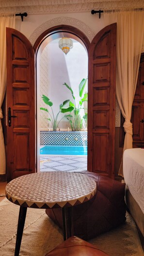 A room with a view through an open door, a round table, and a bed. - Maison Kays  (Marrakech)