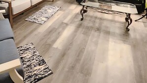 Ein Wohnzimmer mit einer Couch, einem Couchtisch, einem gemusterten Teppich und einem Deckenventilator.
