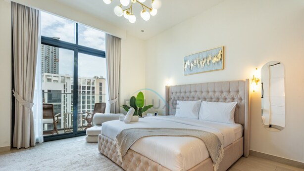 A modern hotel room with a large bed, a view of the city, and a balcony. - Sophisticated Studio Getaway, Minutes Drive to Iconic Dubai Landmarks - Azizi Riviera 45, Al Merkadh (Dubai)