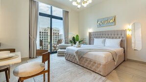 A modern hotel room with a large bed, a dining area, and a view of the city. - Sophisticated Studio Getaway, Minutes Drive to Iconic Dubai Landmarks - Azizi Riviera 45, Al Merkadh (Dubai)
